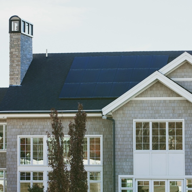 A beautiful two-story home with solar panels installed on the roof.